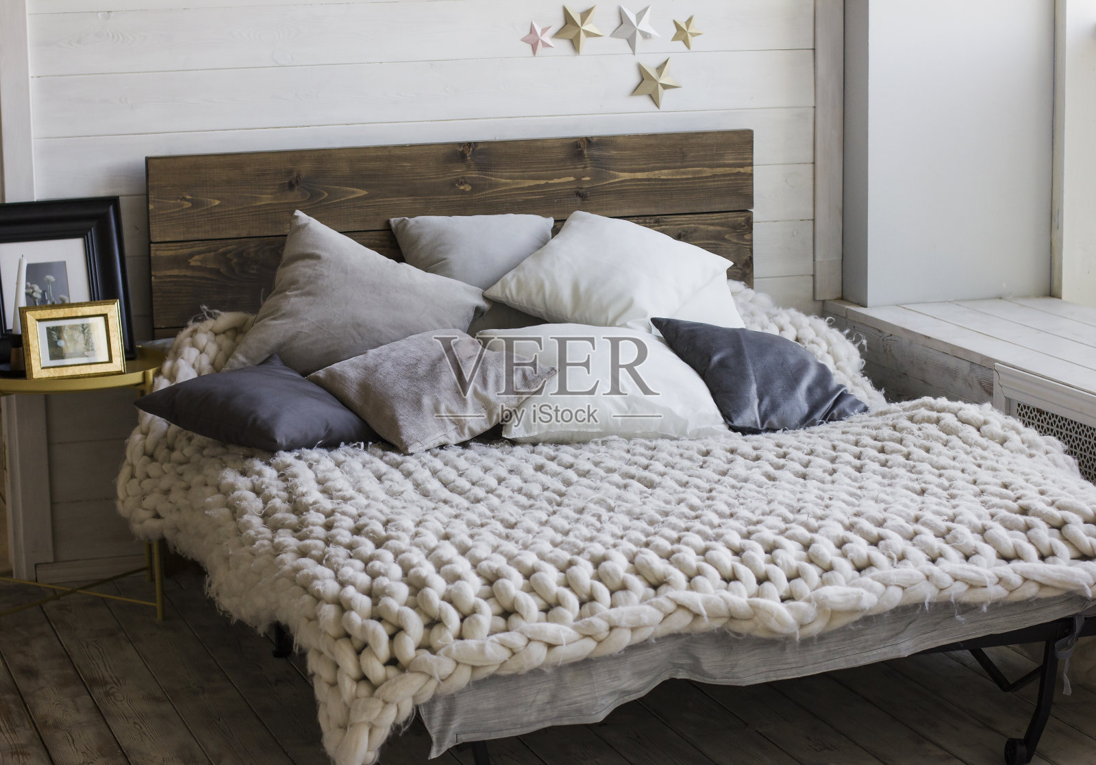 木制床头床，枕头，针织毯子。北欧室内照片摄影图片