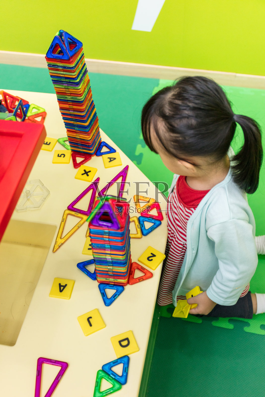 亚洲华人小女孩玩彩色磁铁塑料积木套件照片摄影图片