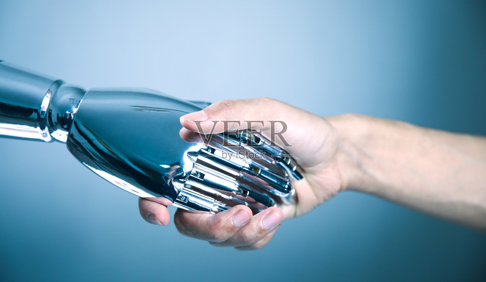 人类与机器人握手照片摄影图片