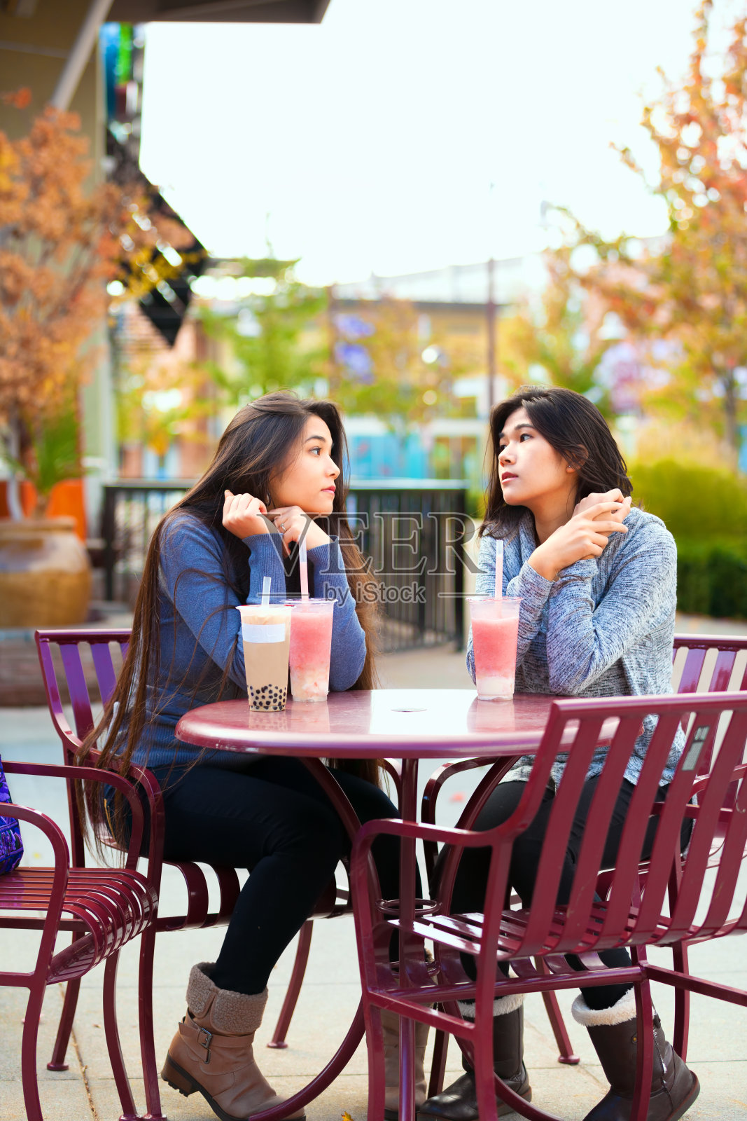 两个十几岁的女孩在户外咖啡馆一起喝珍珠茶照片摄影图片