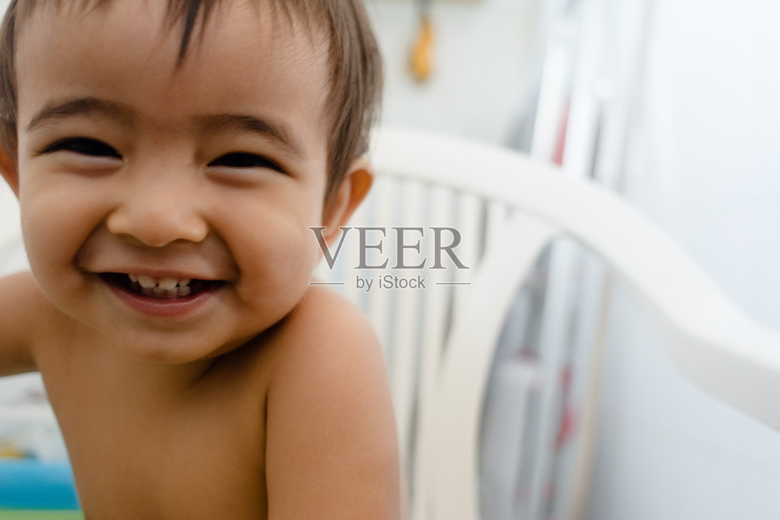 一个可爱的肖像和表情丰富的亚洲一岁男婴微笑快乐照片摄影图片