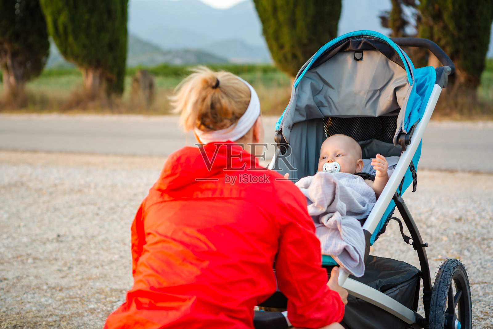 母亲与婴儿车享受母亲的日落风景照片摄影图片