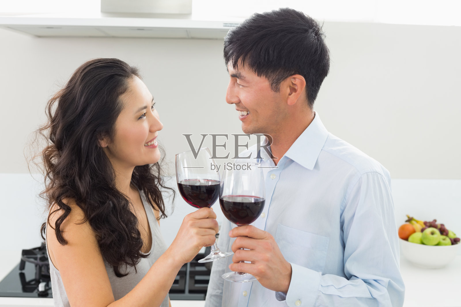 爱的年轻夫妇拿着酒杯在厨房里照片摄影图片