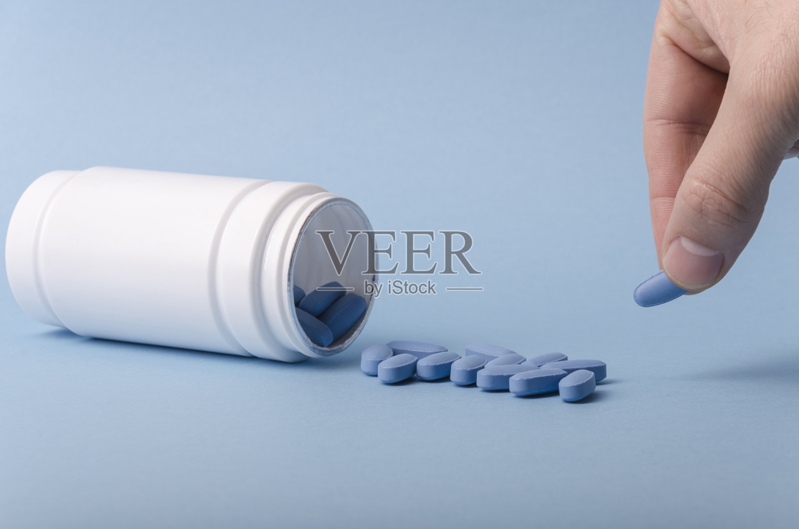 蓝色药片和药瓶，用于医学研究。照片摄影图片