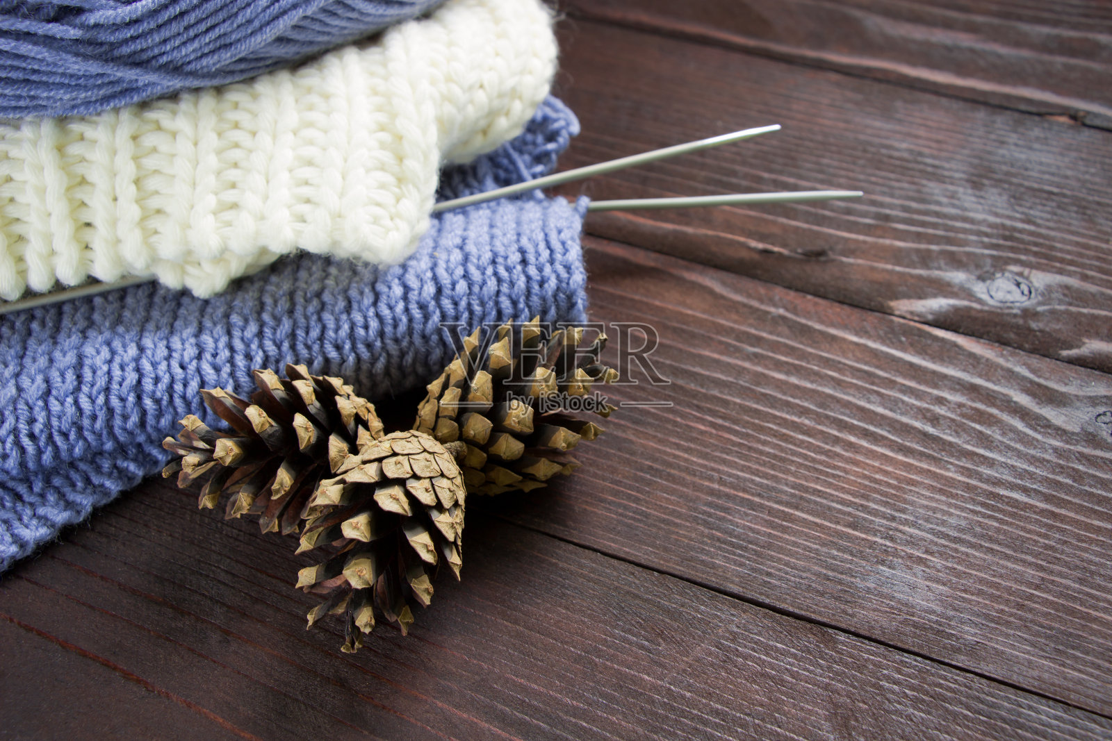 手工编织的衣服，线，锥和编织针在木制的背景。手工工艺。秋冬概念照片摄影图片