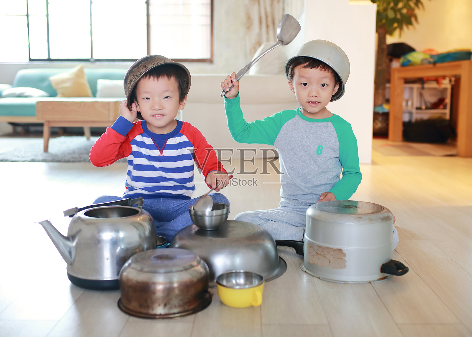 两个兄弟在地板上玩着锅碗瓢盆照片摄影图片