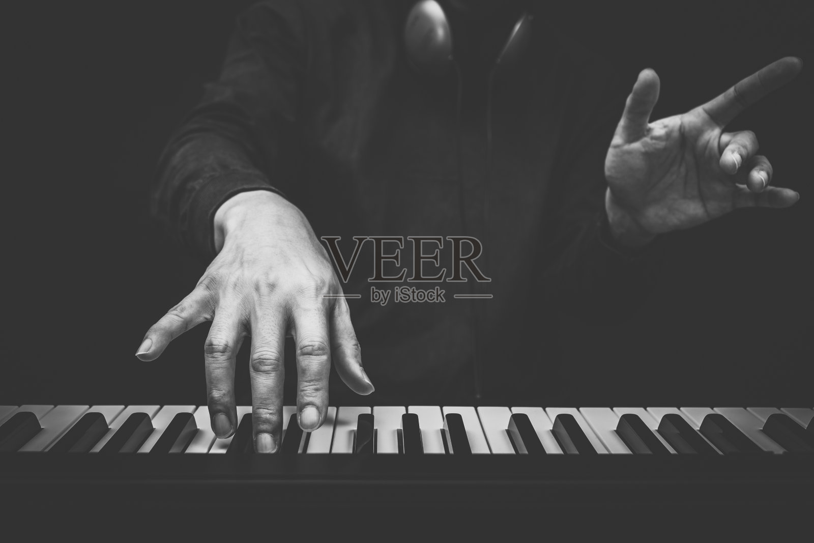 音乐家的手在钢琴键上弹奏，黑白相间照片摄影图片