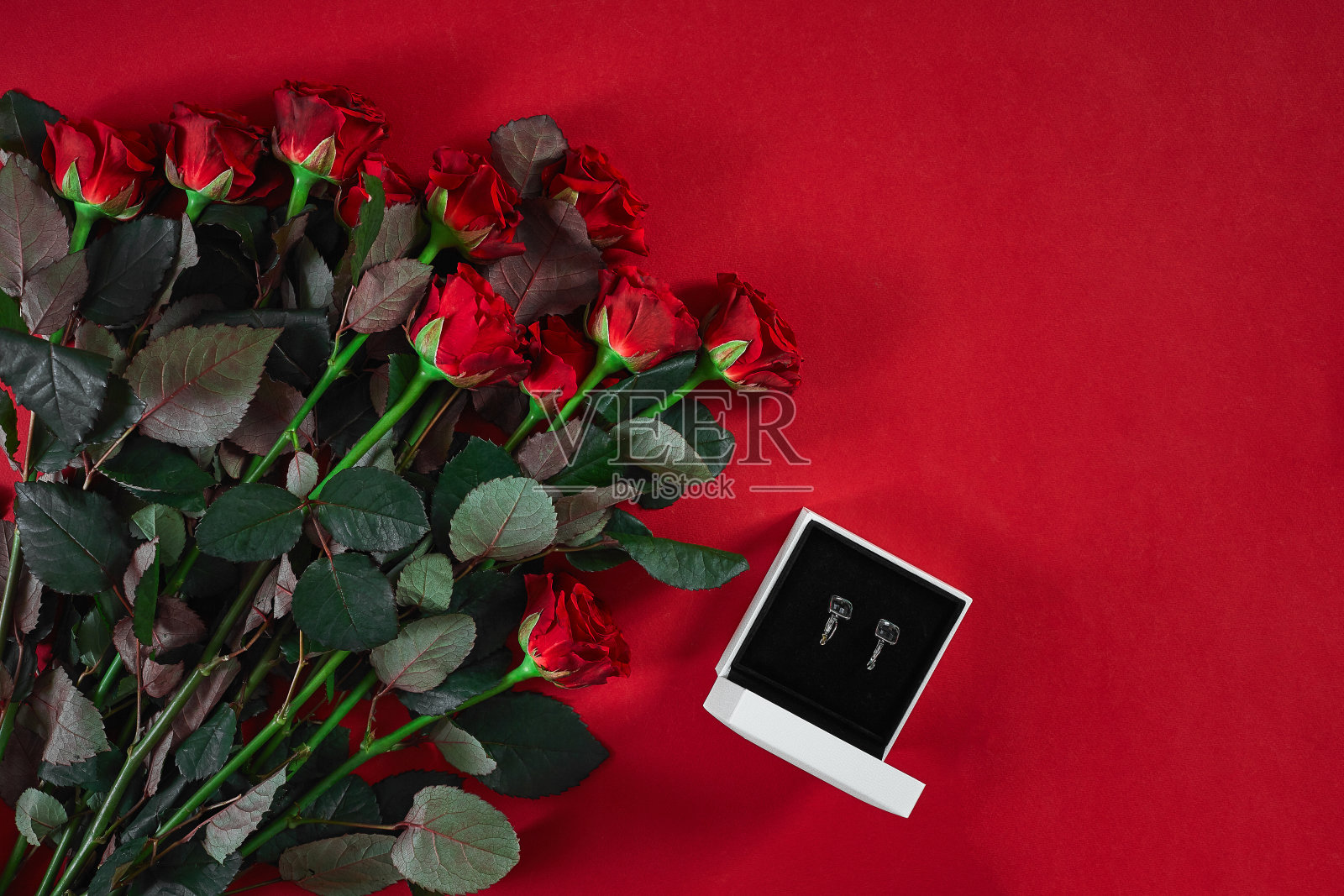 珠宝一套金耳环在礼品盒和红玫瑰照片摄影图片