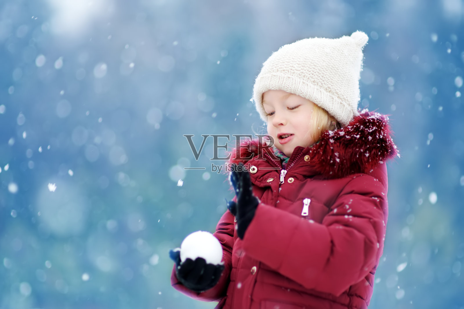 可爱的小女孩在美丽的冬季公园玩。可爱的孩子在雪地里玩耍。照片摄影图片