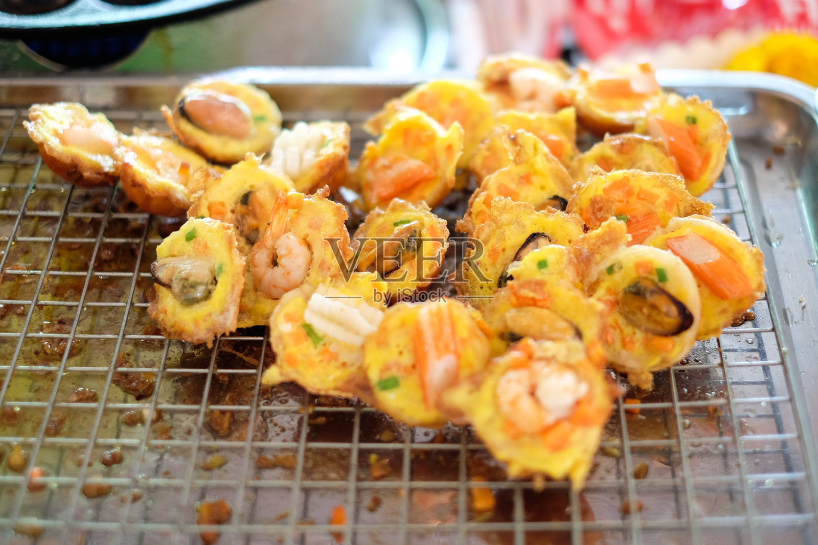 金属格格的章鱼烧丸子里放着“贻贝、虾、鱿鱼/章鱼”——日式或泰式食物背景或质地。照片摄影图片