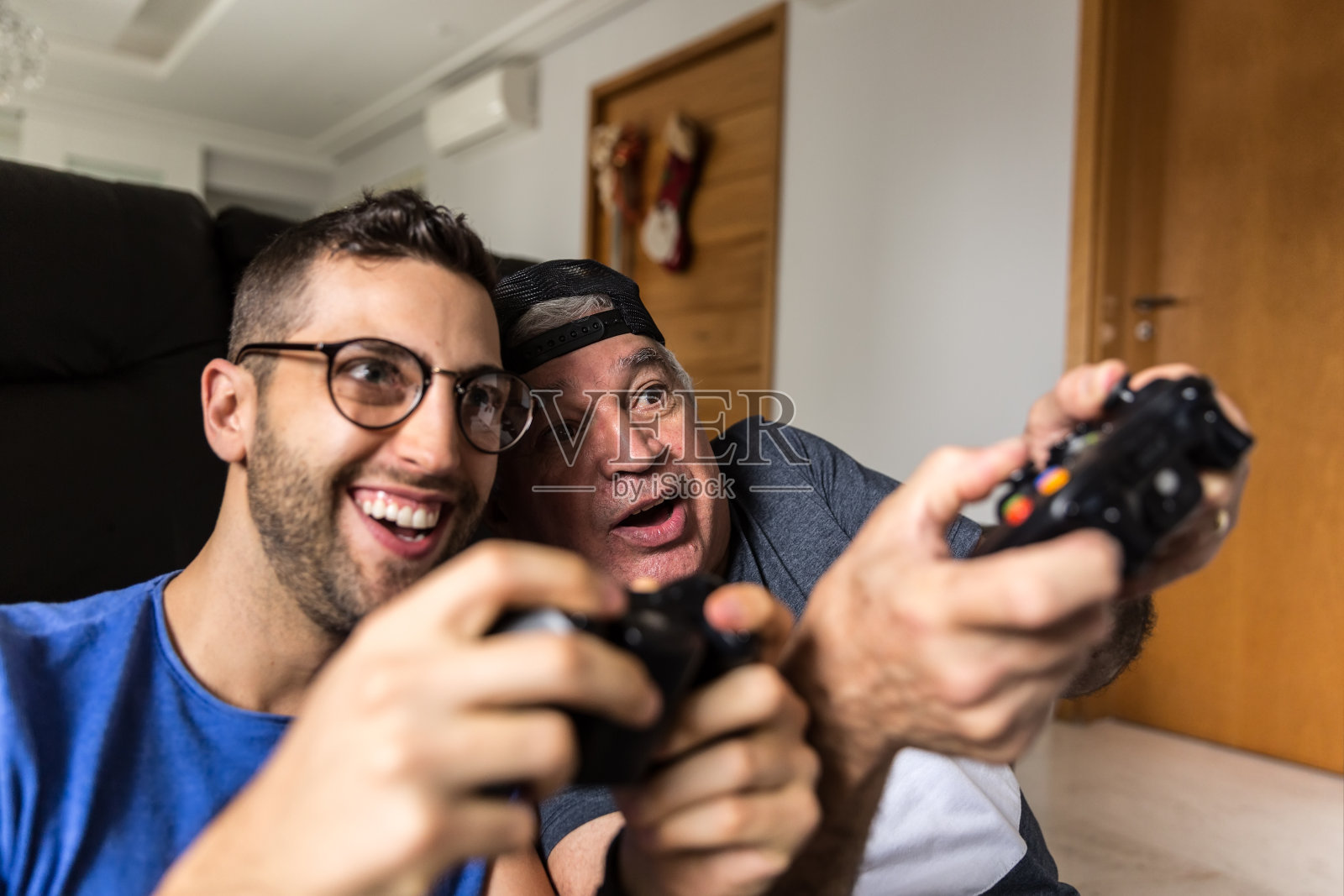 爸爸和儿子在家里玩游戏机照片摄影图片