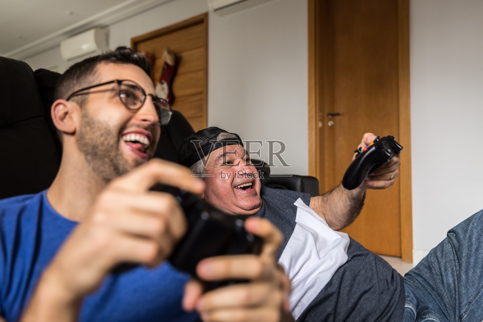 爸爸和儿子在家里玩游戏机照片摄影图片