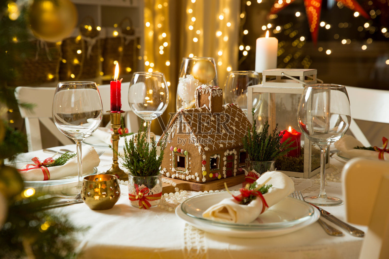 漂亮的餐桌上有圣诞装饰品，蜡烛和灯笼照片摄影图片
