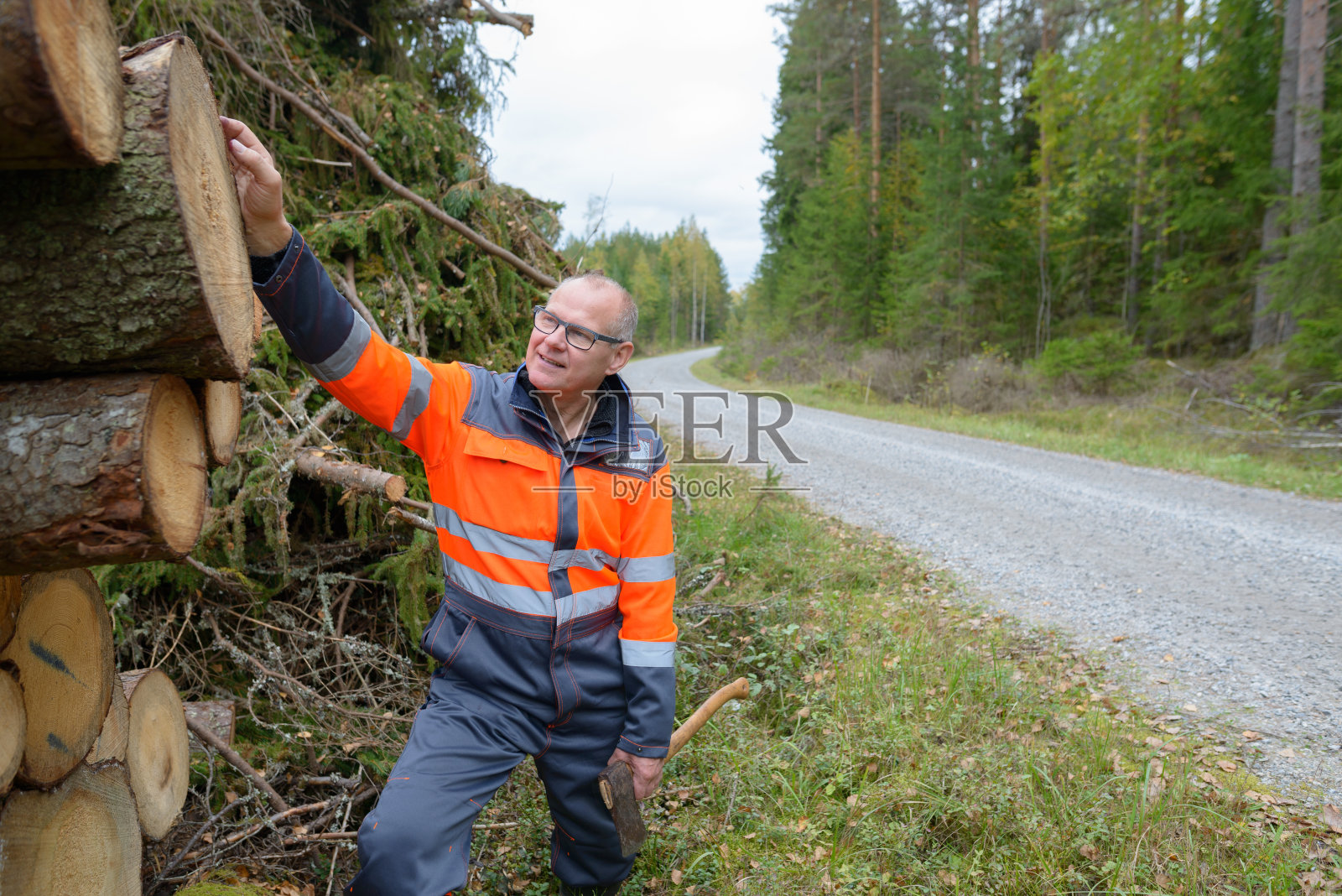 成熟英俊的男人在森林里工作砍伐树木照片摄影图片