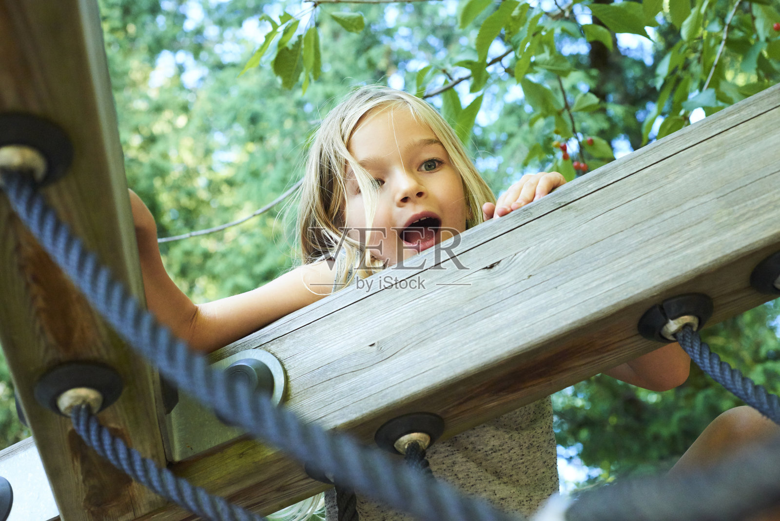 一个美丽的女孩的肖像在一个绳子公园的树木。照片摄影图片