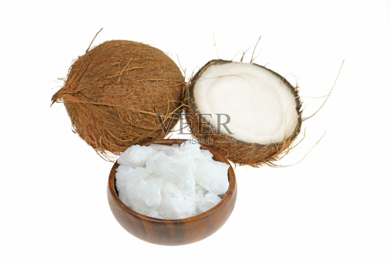 天然未精制椰子油。椰子在一个切割和白色天然椰子油在棕色木制圆杯孤立在白色的背景照片摄影图片
