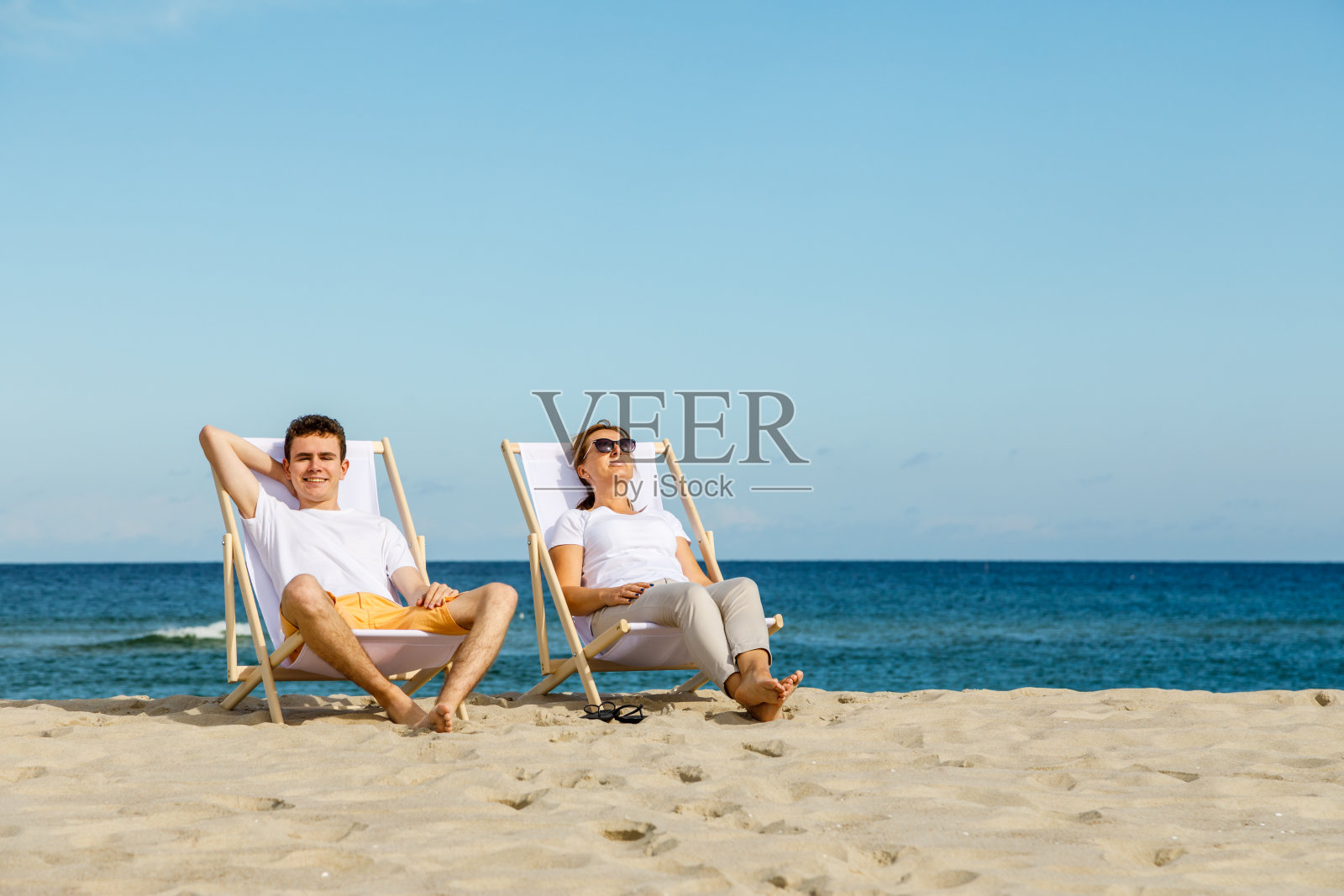 女人和男人在海滩上放松照片摄影图片