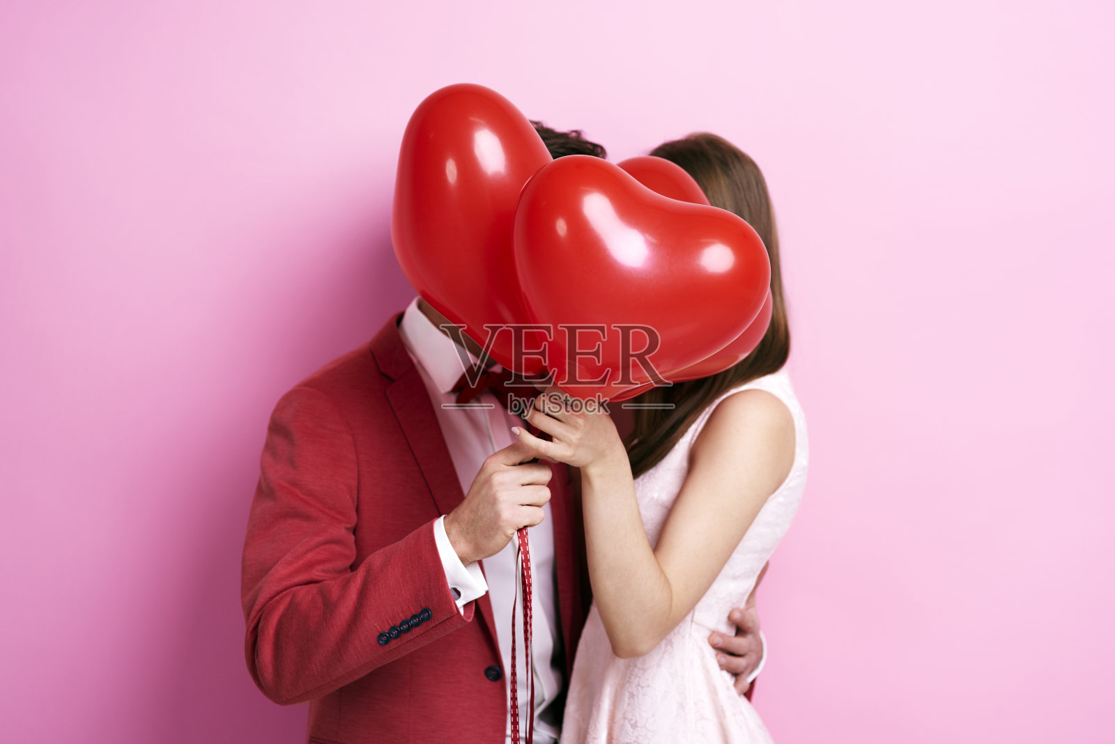 情侣在气球后面接吻照片摄影图片
