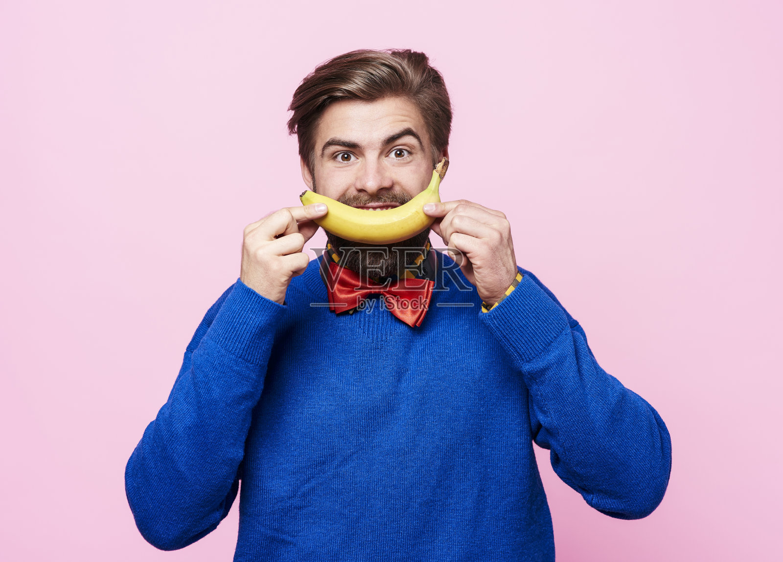 一个人把香蕉放在嘴边照片摄影图片