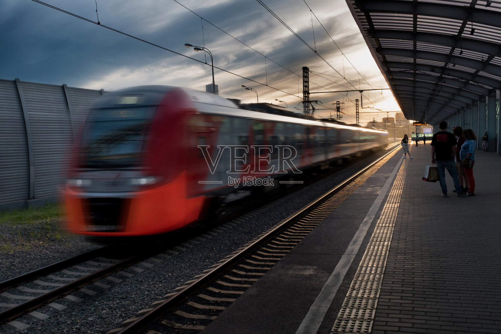 日落时分，高速列车在欧洲火车站上行驶照片摄影图片