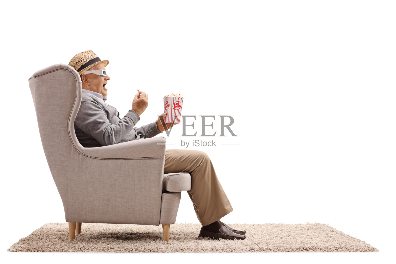 一个戴着3d眼镜坐在扶手椅上吃着爆米花的成熟男人照片摄影图片