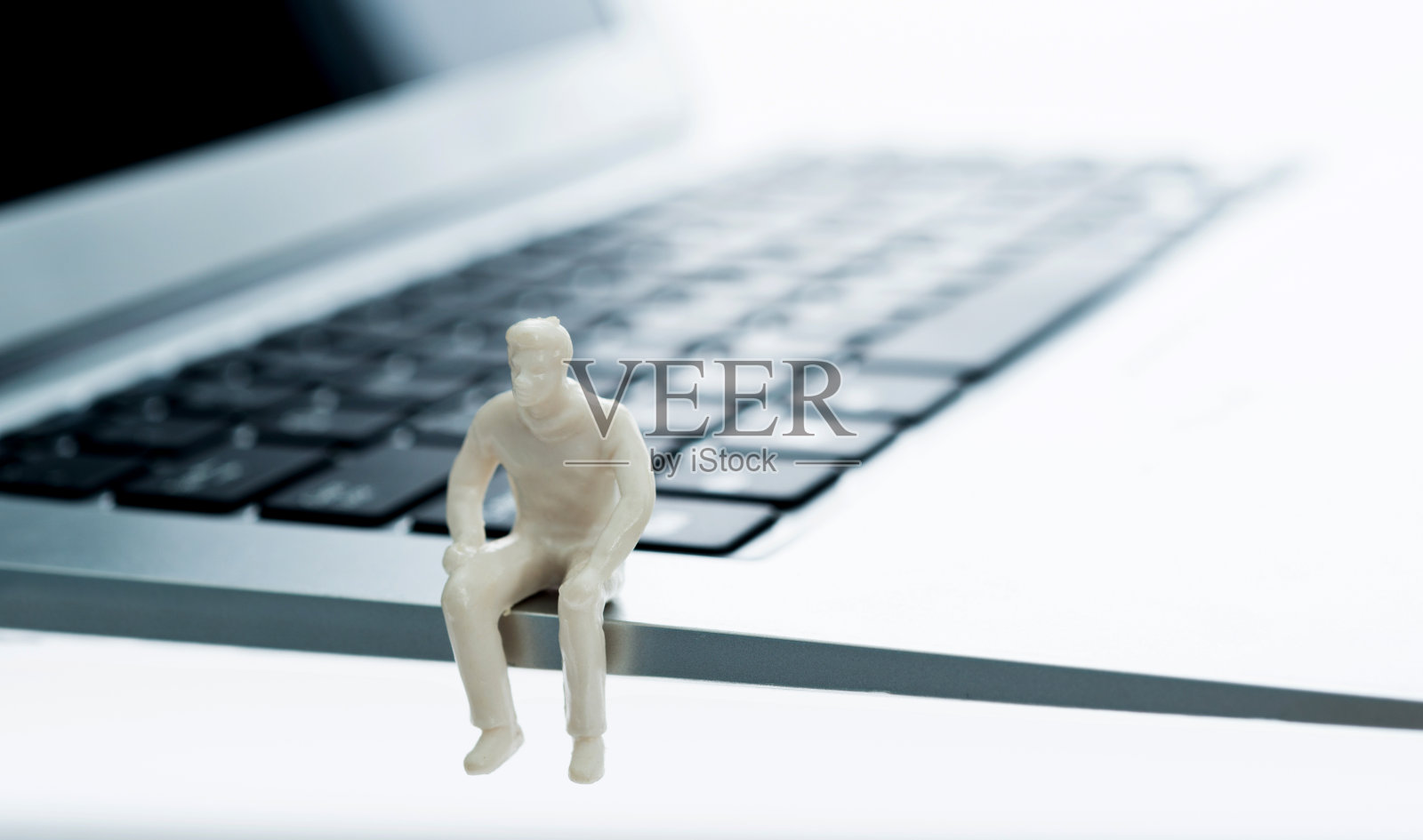 人形雕像坐在键盘上照片摄影图片