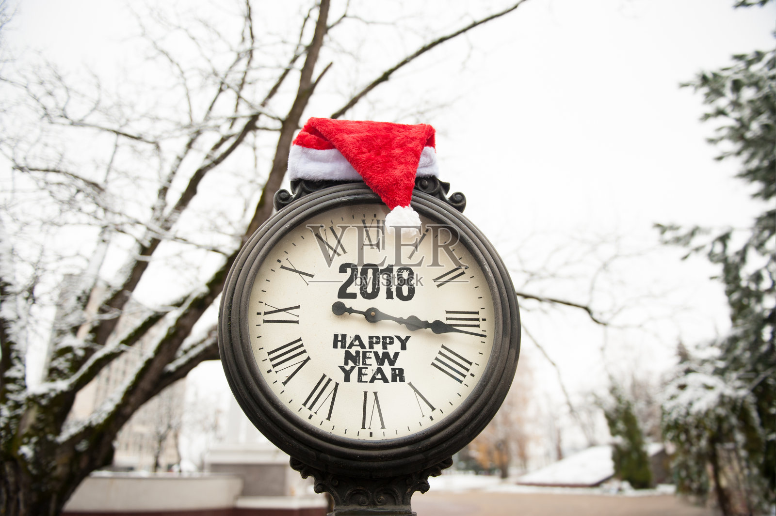 上面刻着“2018年新年快乐”的老式街道钟和圣诞老人帽照片摄影图片