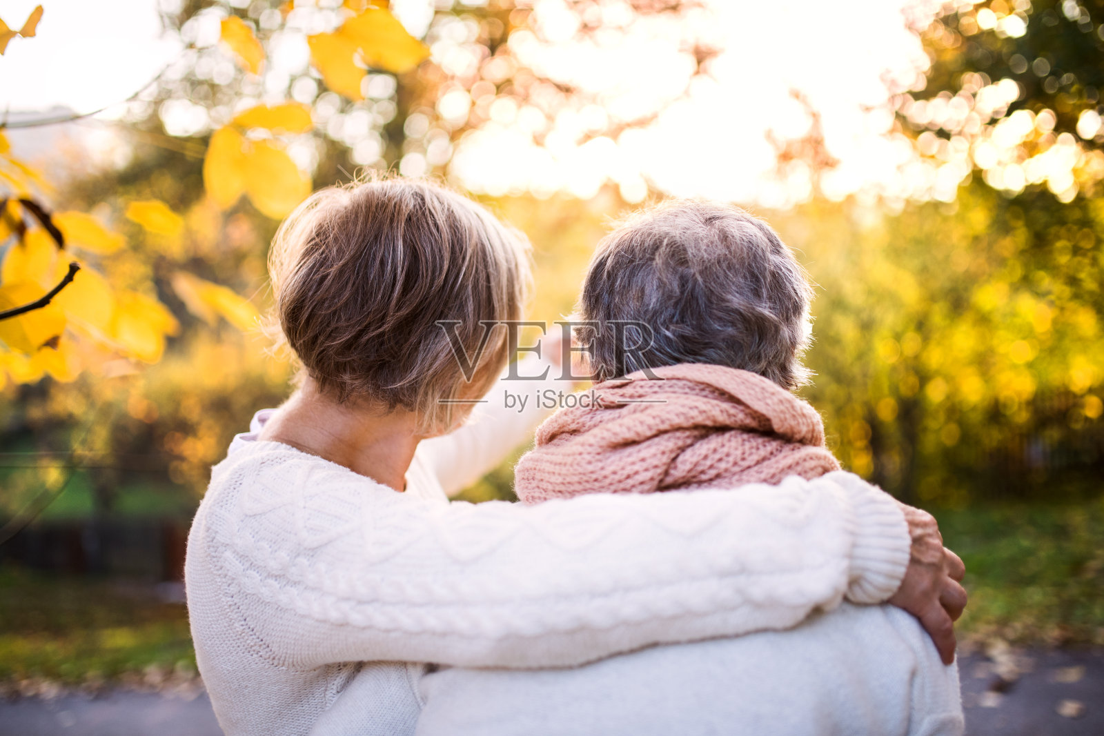 老年妇女在秋天的大自然中散步。照片摄影图片