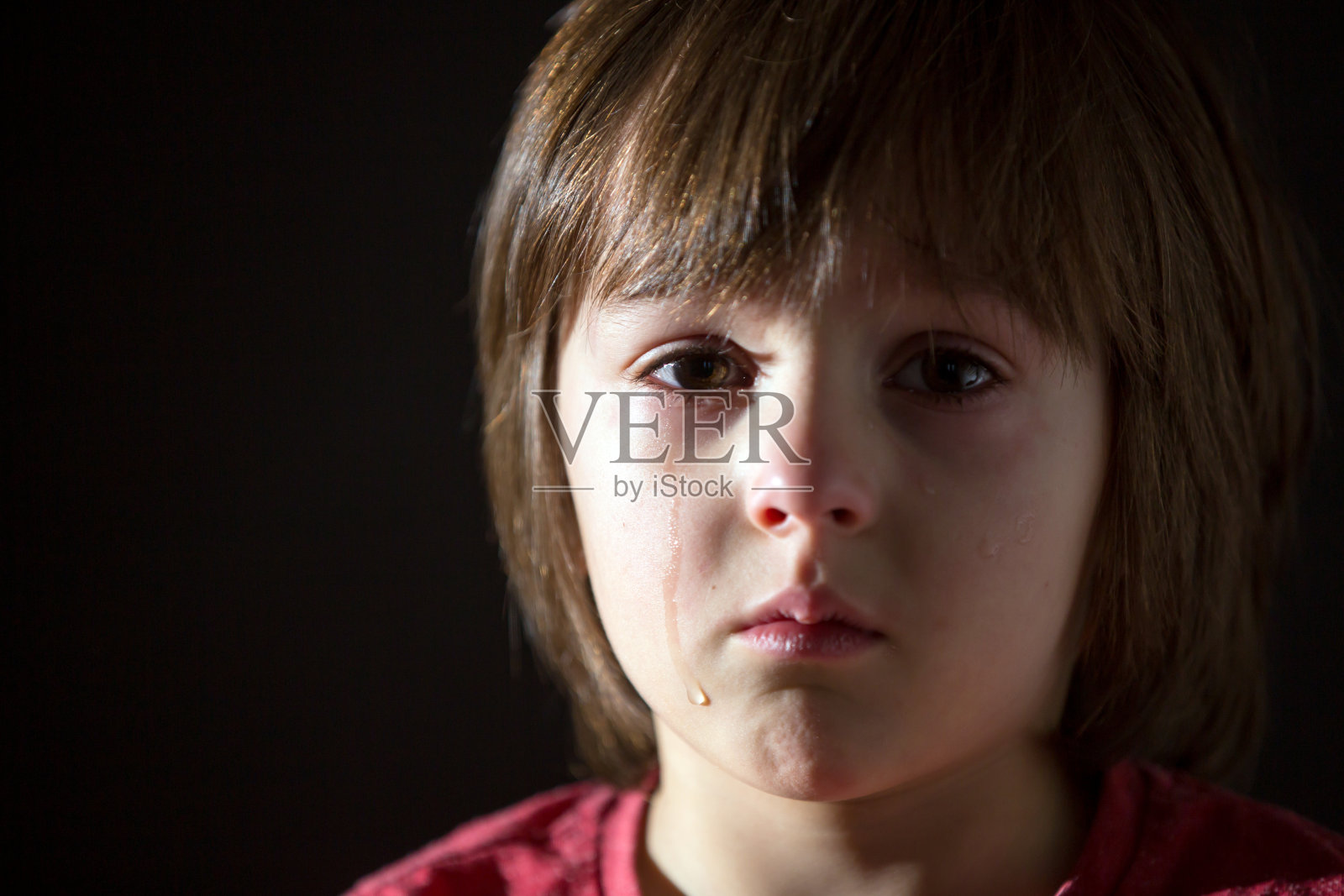 可怜的小孩，哭闹着，抱着毛绒玩具照片摄影图片