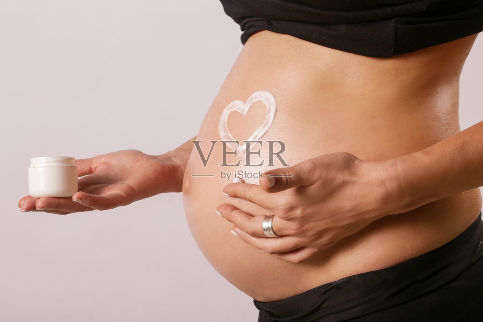 孕妇在腹部涂抹保湿霜，防止妊娠纹照片摄影图片