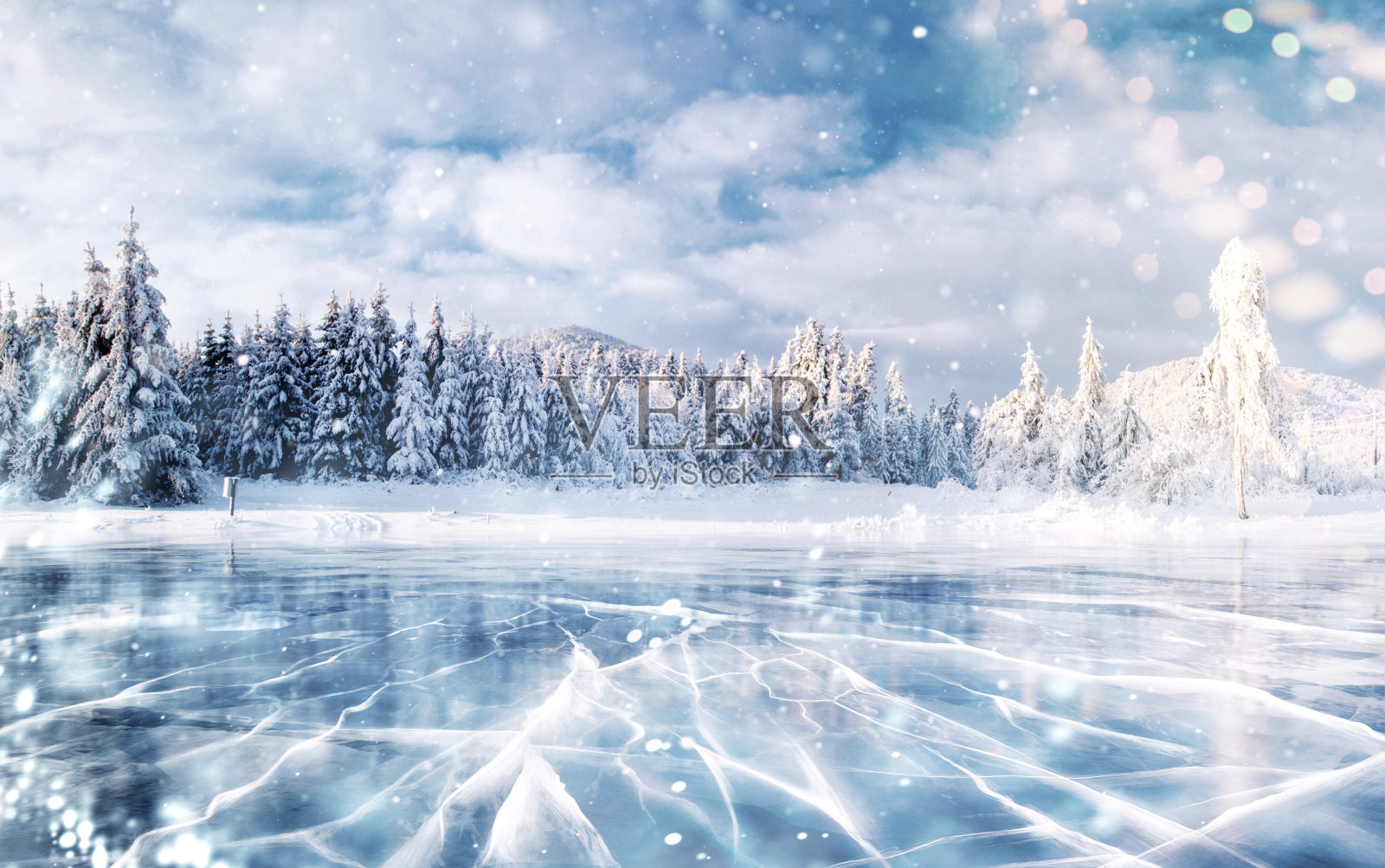 蓝色的冰和冰表面的裂缝。冬天山上结冰的湖。它正在下雪。松树山。冬天。喀尔巴阡山脉的乌克兰欧洲照片摄影图片