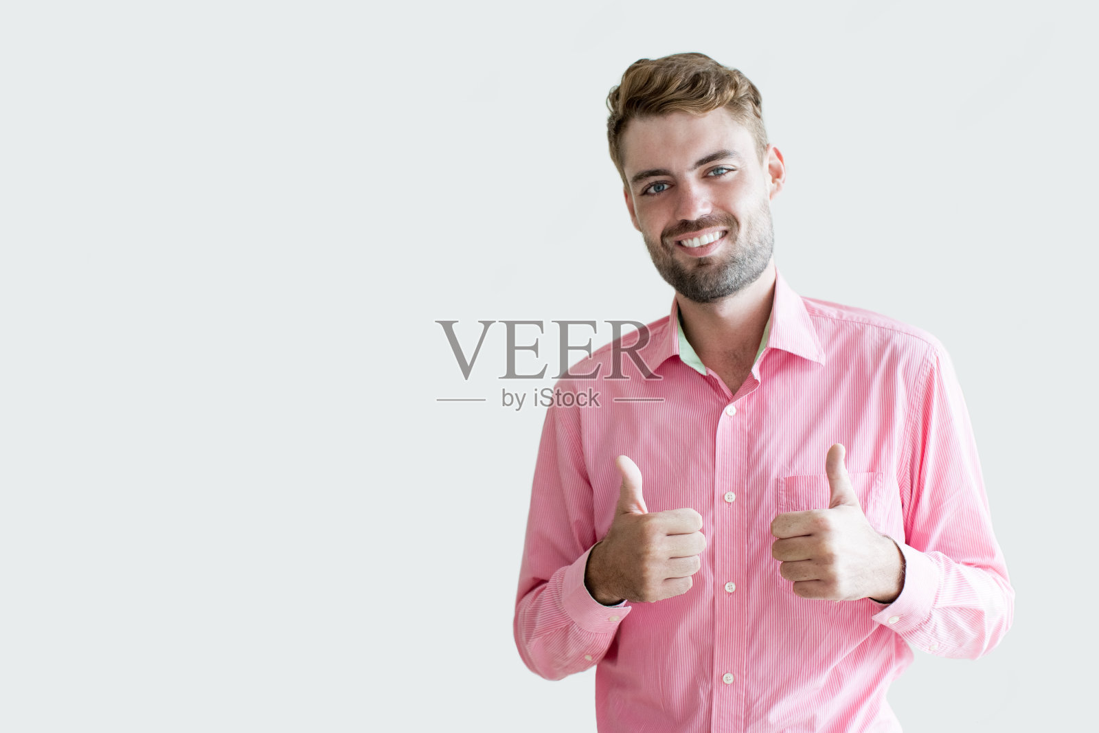 微笑的年轻英俊的男人竖起大拇指照片摄影图片