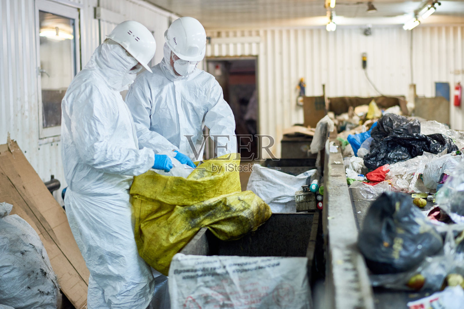 工人在废物处理厂分拣可回收物料照片摄影图片