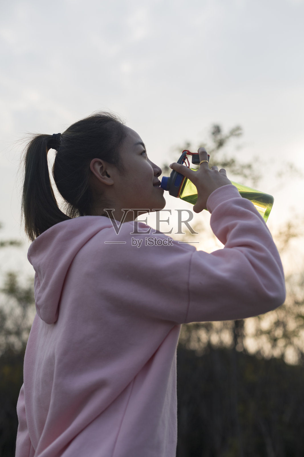 亚洲跑步者在运动后喝水照片摄影图片