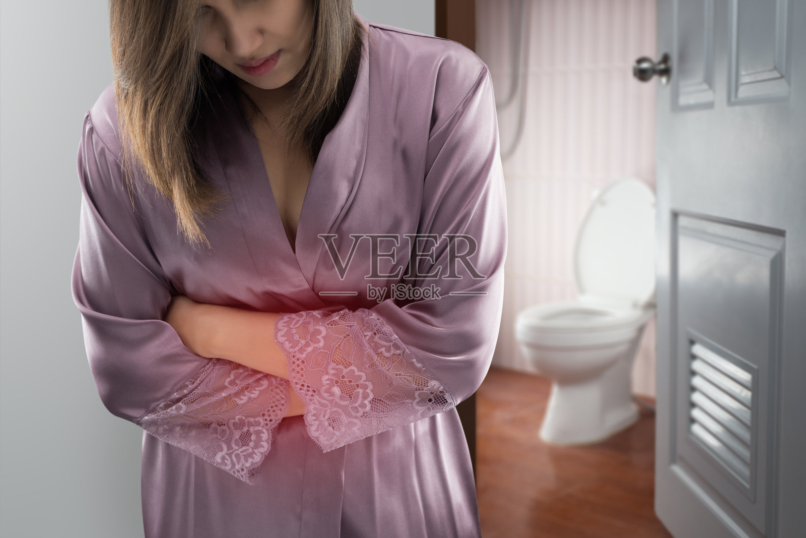 身着紫缎袍的女子起床去洗手间，亚洲妇女胃痛，概念与健康问题照片摄影图片