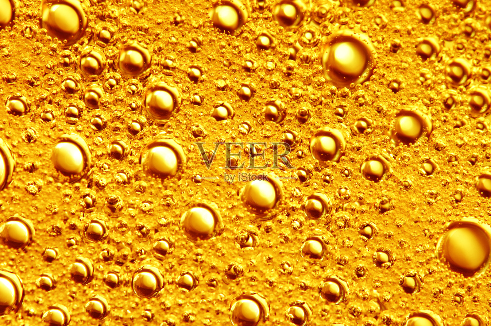 金色的背景与大的和小的金色气泡油里面的黄金液体。照片摄影图片