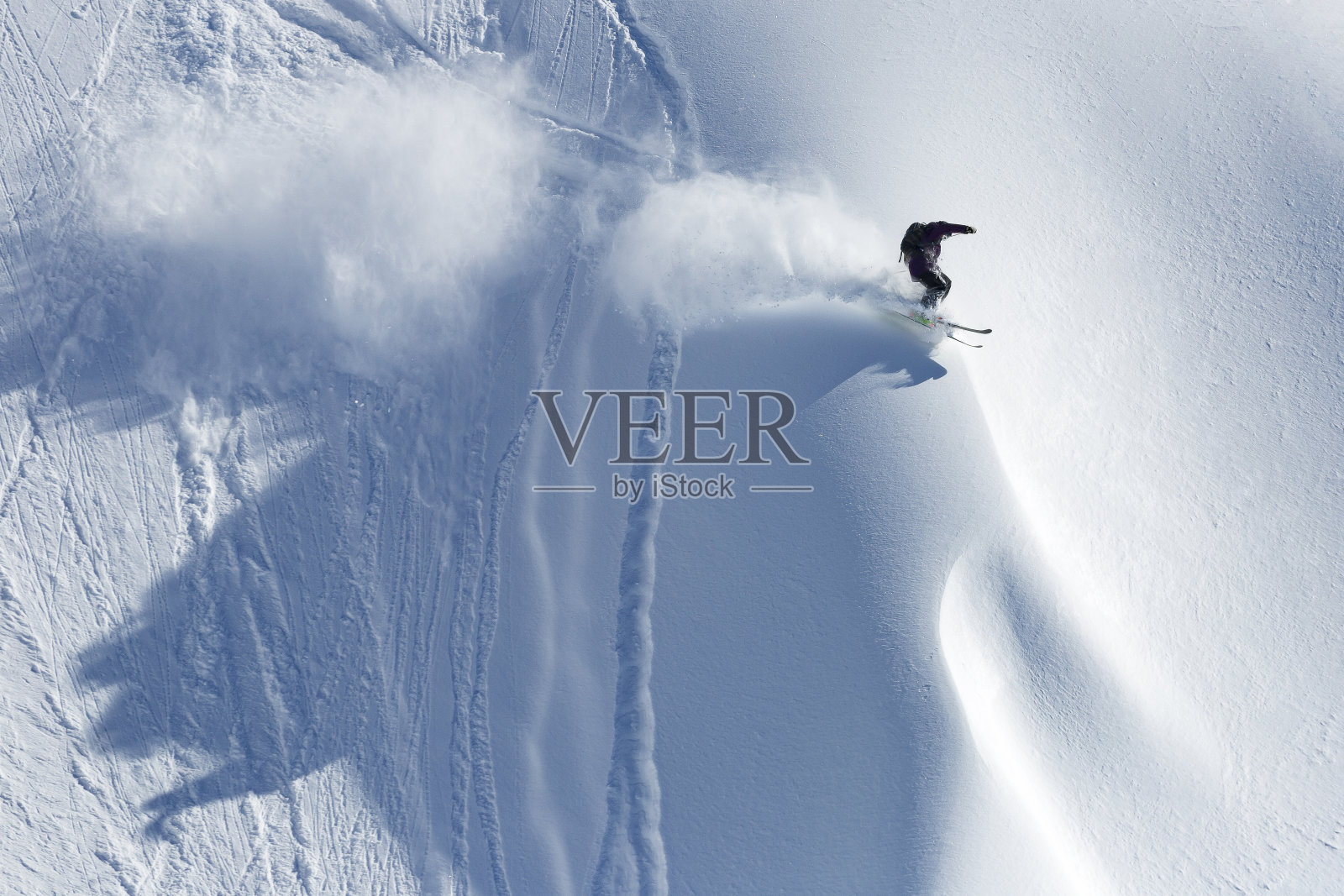 极速滑雪者骑着新鲜的粉末雪下山照片摄影图片