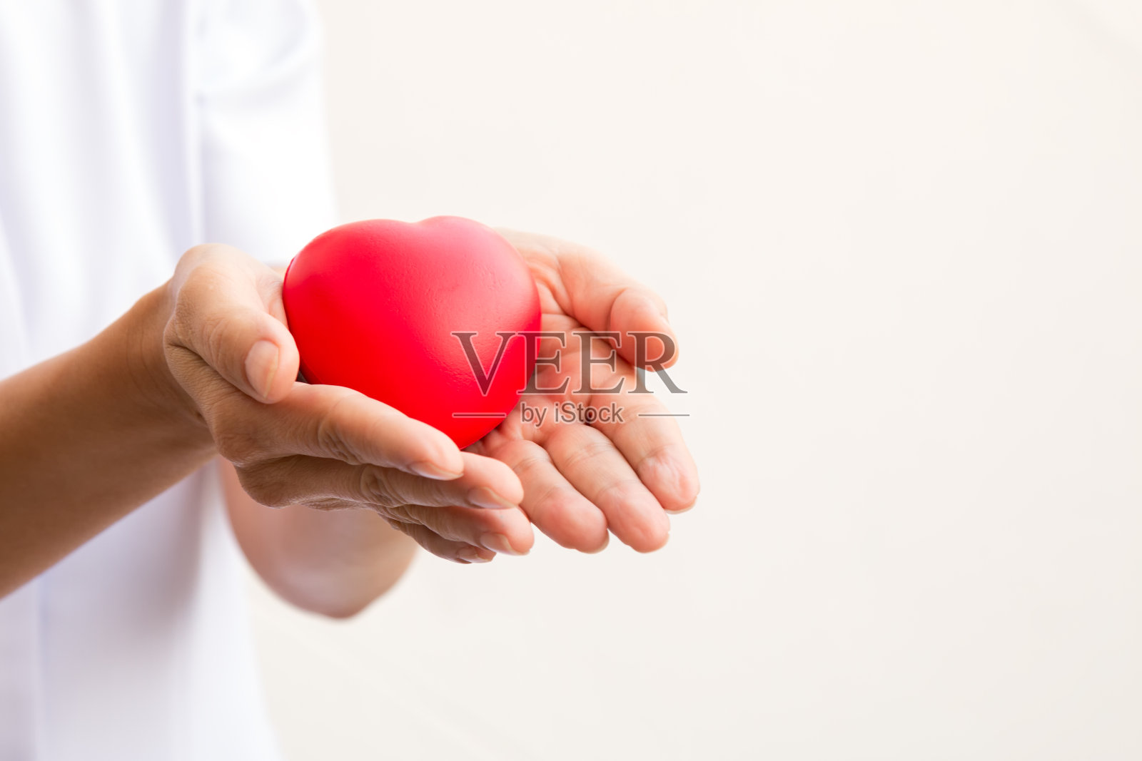 护士双手捧着红心;医疗保健的概念;情人节的爱之心照片摄影图片