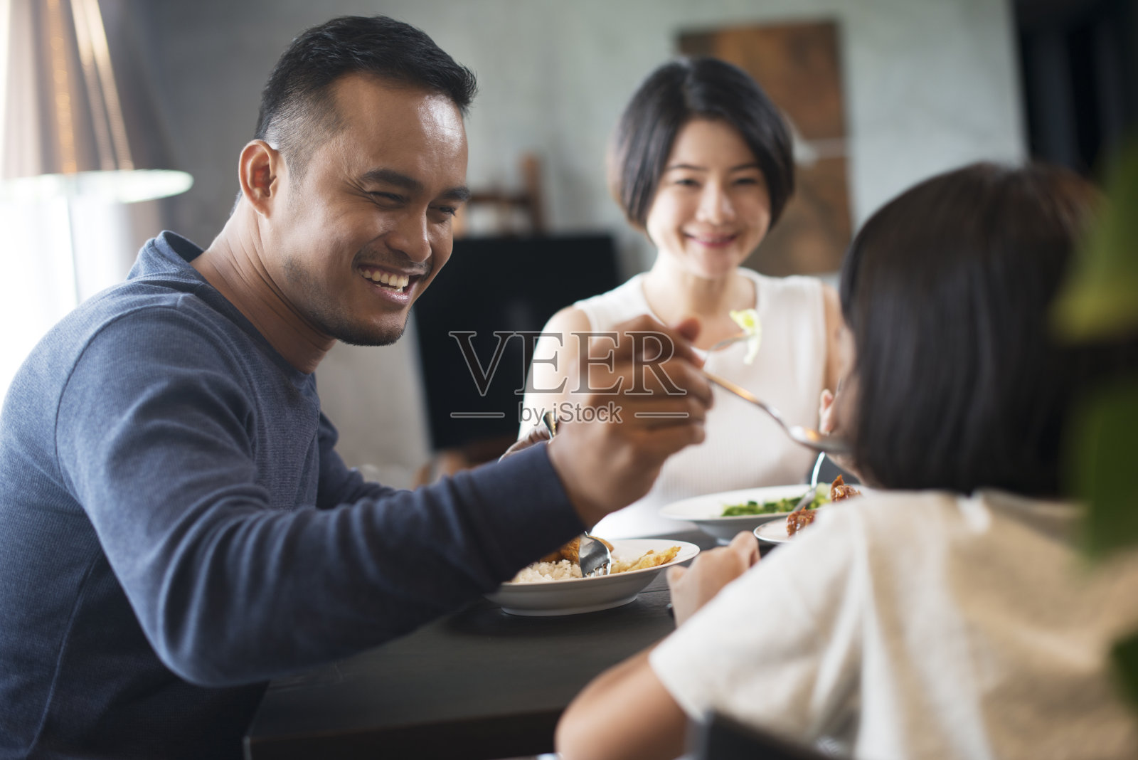 在家里吃饭的亚洲家庭。照片摄影图片