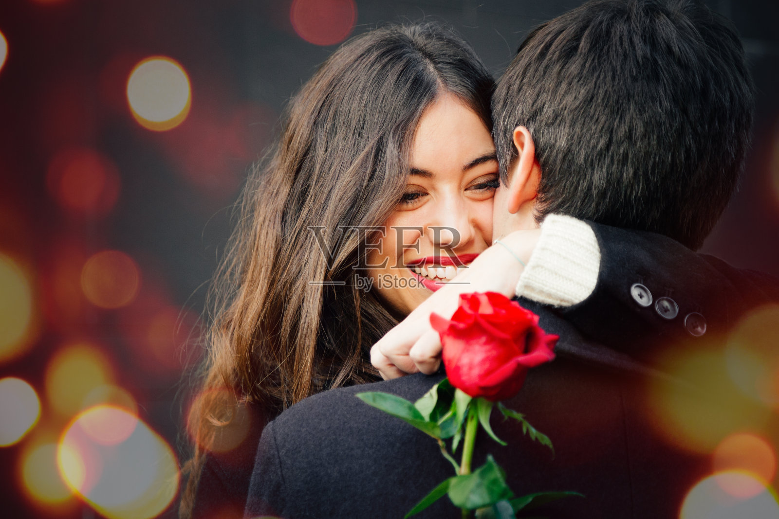 一对幸福的情侣在街上拥着一朵玫瑰照片摄影图片