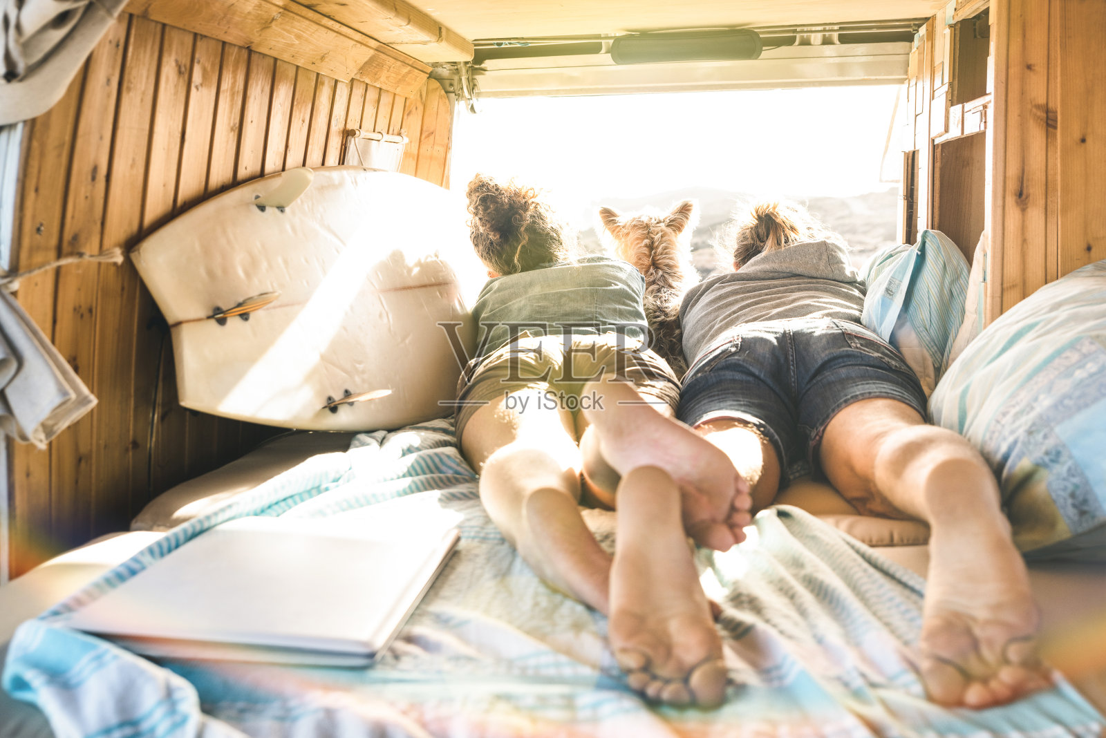 潮人夫妇与可爱的狗一起旅行在古董货车运输-生活灵感概念与嬉皮人在小型货车冒险旅行看日落在放松时刻-温暖的阳光过滤器照片摄影图片