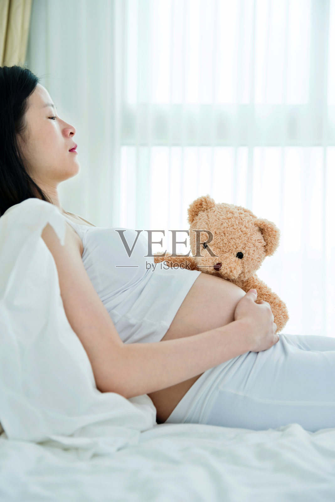 孕妇和熊睡觉照片摄影图片