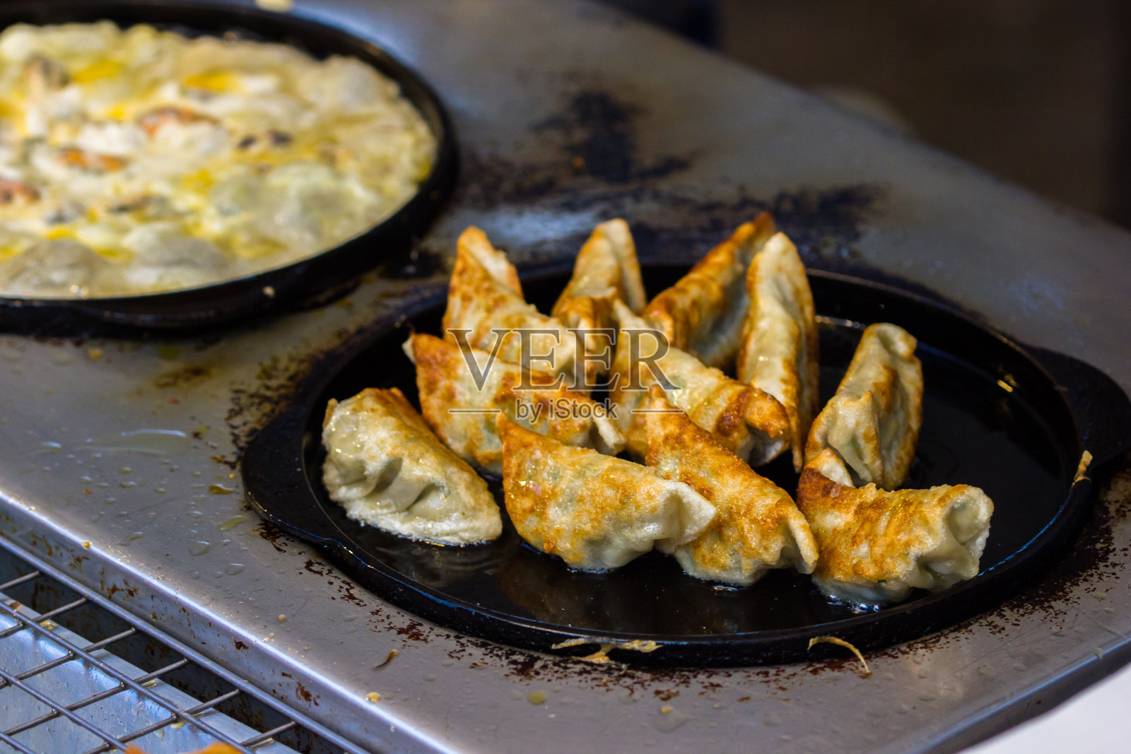 在热的黑平底锅上吃煎饺很不错。可以吃了。亚洲食物的背景。照片摄影图片