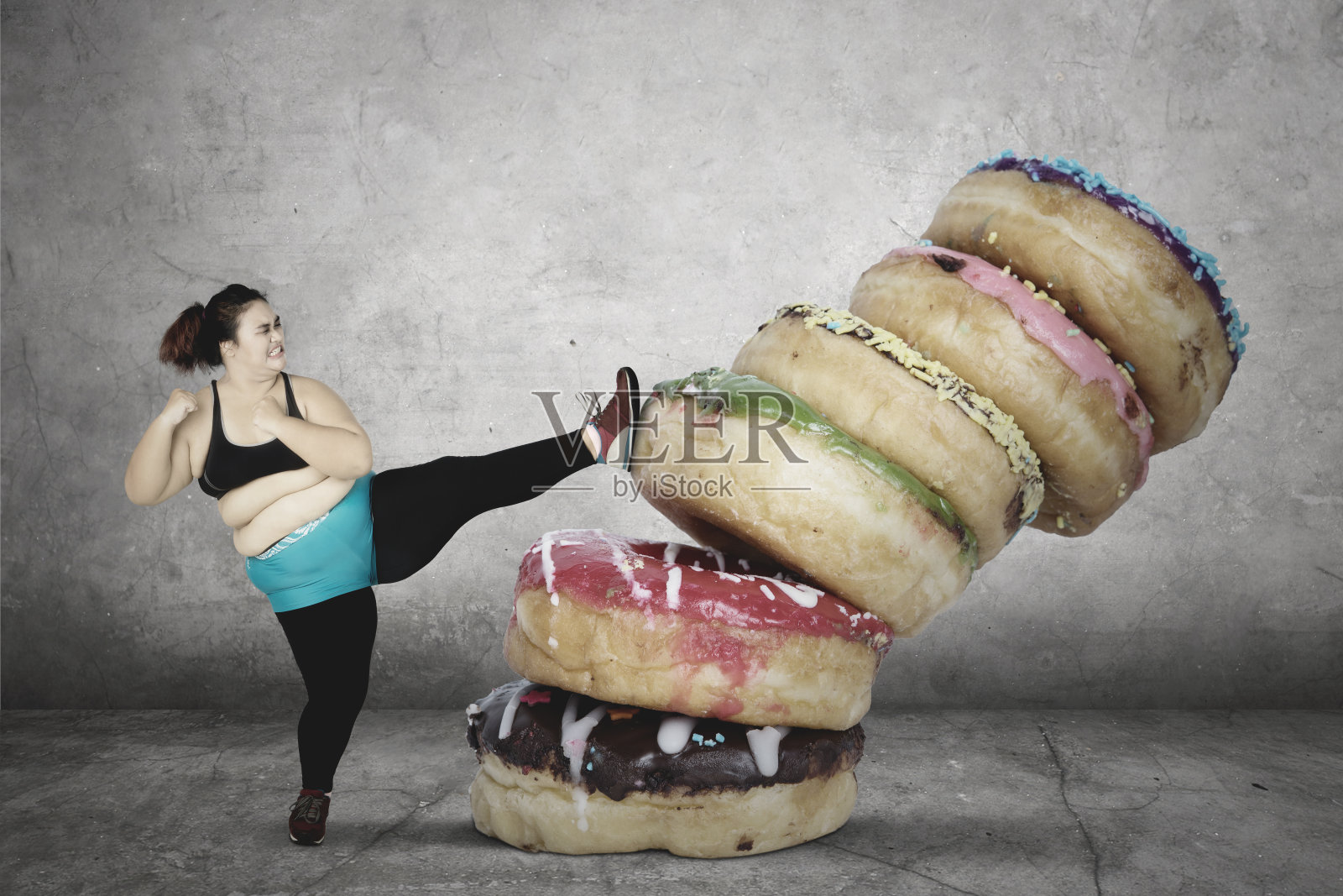 胖女人踢着一堆甜甜圈照片摄影图片