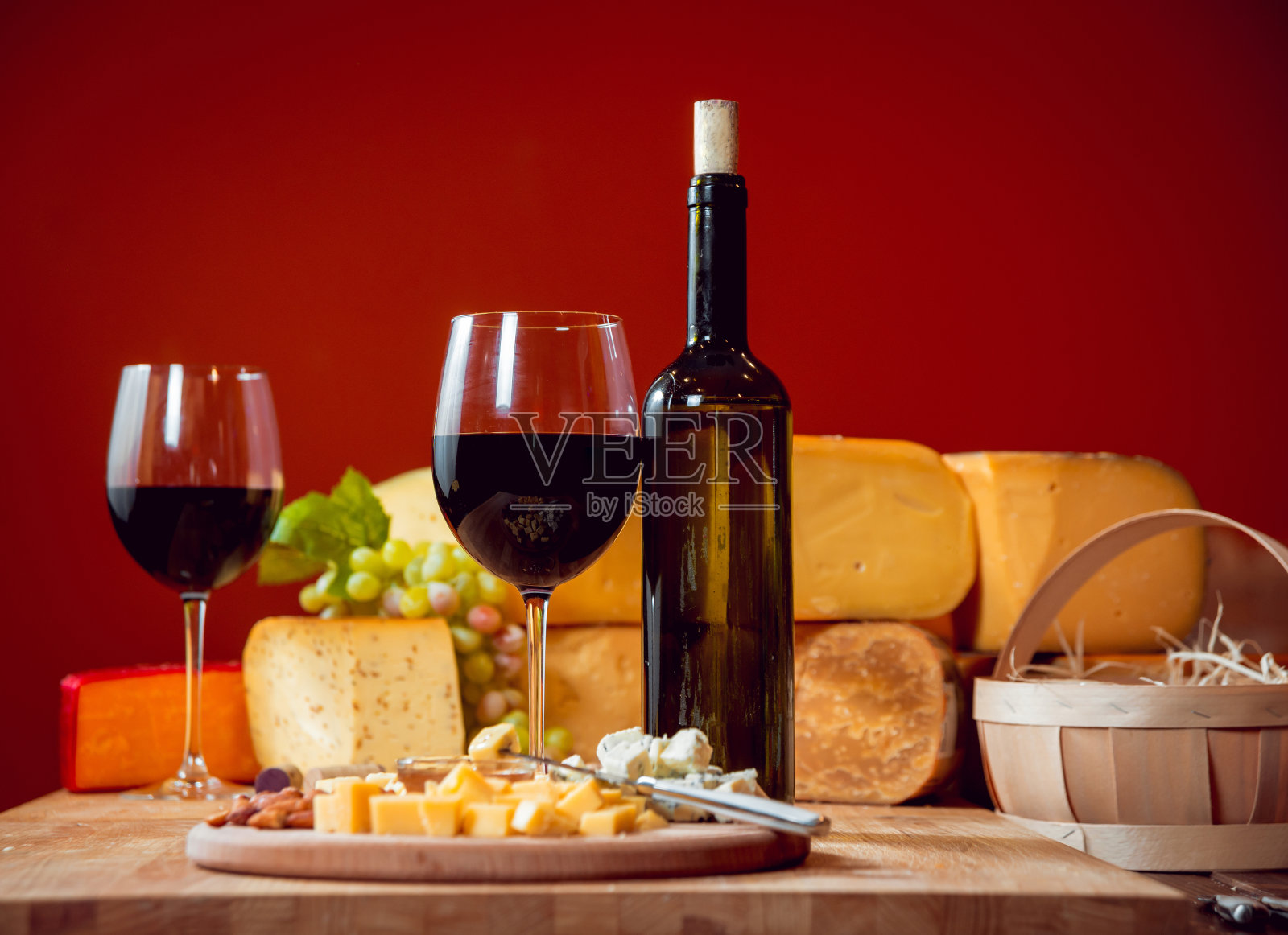 黑桌子上放着奶酪和葡萄酒。照片摄影图片