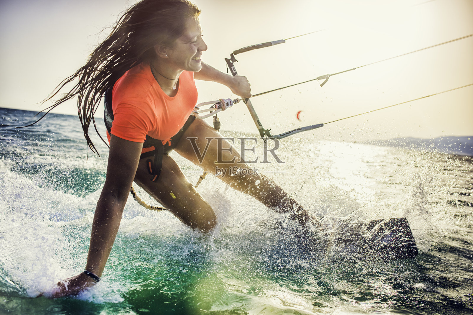 微笑的年轻女子风筝滑板在海上照片摄影图片
