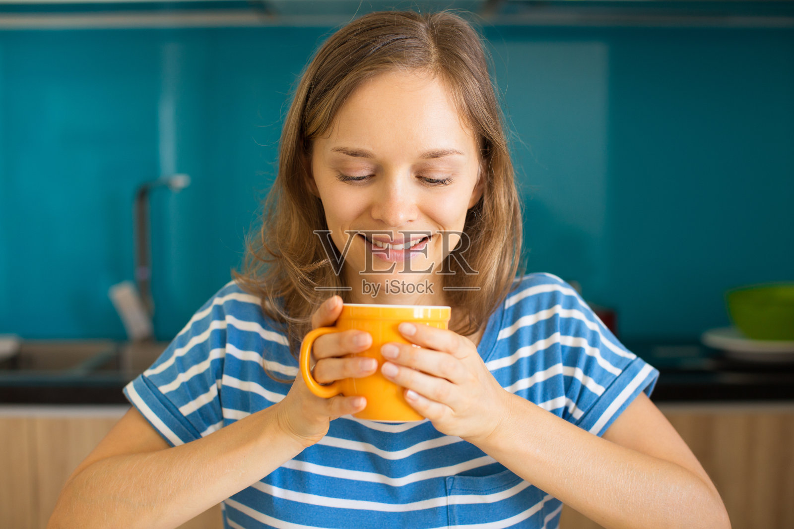 微笑的女人在厨房喝茶照片摄影图片