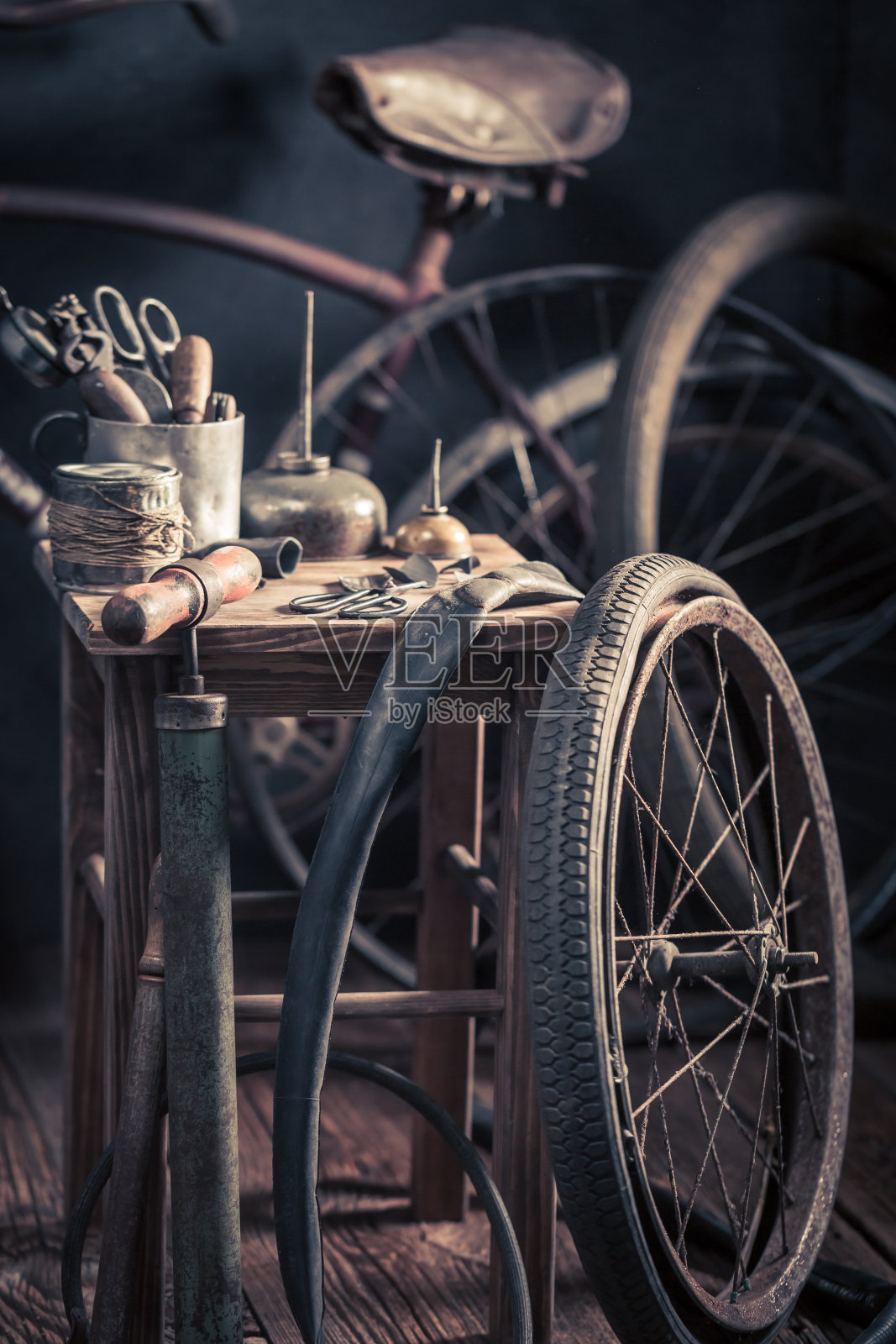 有轮子、工具和橡胶补丁的老式自行车修理厂照片摄影图片