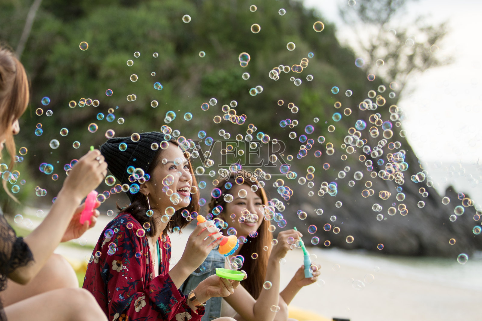 年轻的女性在户外玩和吹泡泡照片摄影图片