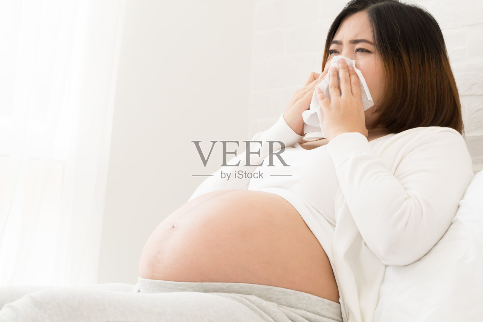 怀孕期间的流感，通常开始时伴有发烧、疼痛和疲劳，随后出现鼻塞、打喷嚏、喉咙痛等感冒症状，对孕妇尤其危险照片摄影图片